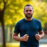 Man jogging outdoors with vibrant energy.